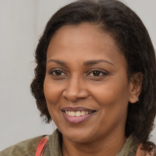Joyful black adult female with medium  brown hair and brown eyes