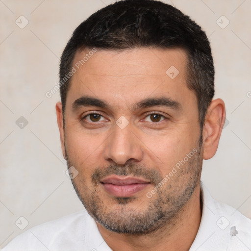 Joyful white young-adult male with short  black hair and brown eyes