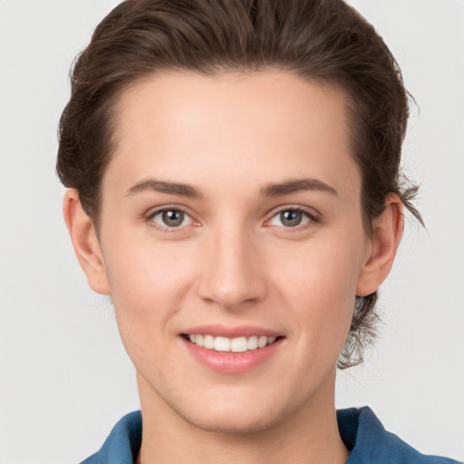 Joyful white young-adult female with short  brown hair and grey eyes