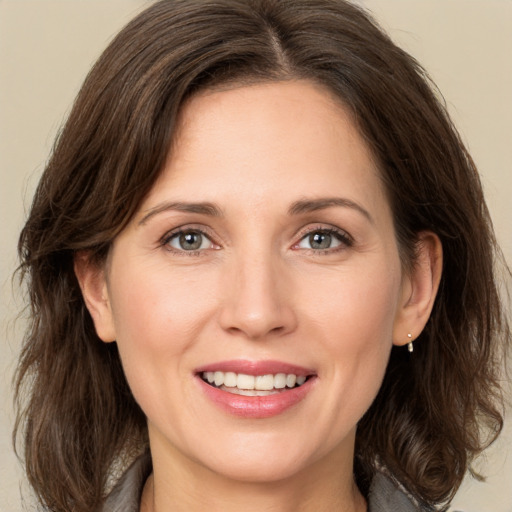 Joyful white adult female with medium  brown hair and green eyes