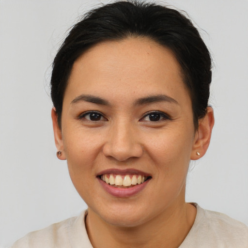 Joyful asian young-adult female with short  brown hair and brown eyes