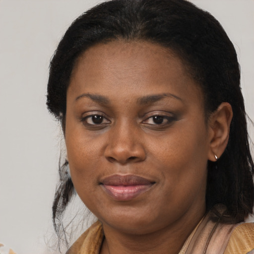 Joyful black adult female with long  brown hair and brown eyes