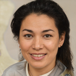 Joyful latino adult female with medium  brown hair and brown eyes