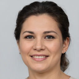 Joyful white adult female with medium  brown hair and brown eyes