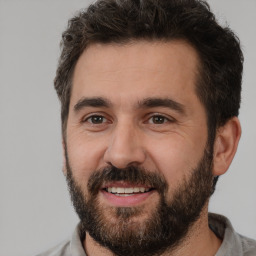 Joyful white adult male with short  brown hair and brown eyes