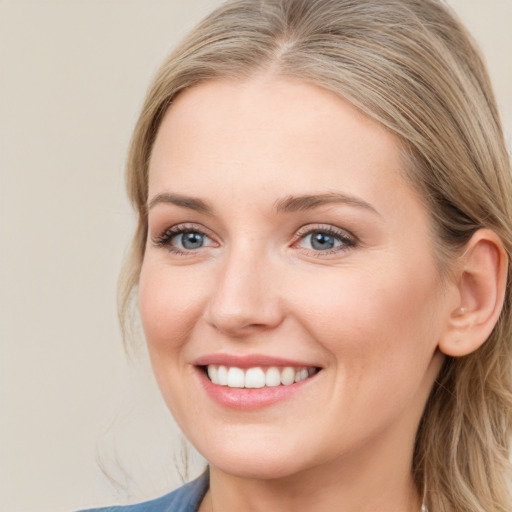 Joyful white young-adult female with long  brown hair and blue eyes