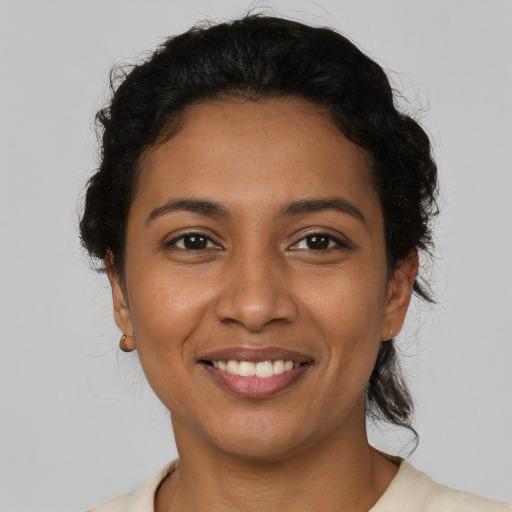 Joyful latino young-adult female with short  brown hair and brown eyes