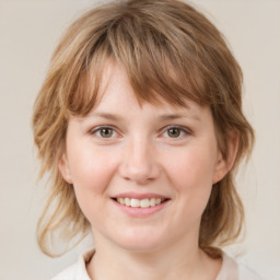 Joyful white young-adult female with medium  brown hair and blue eyes