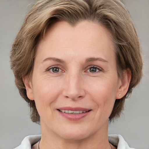 Joyful white adult female with medium  brown hair and grey eyes