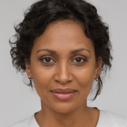 Joyful black adult female with medium  brown hair and brown eyes