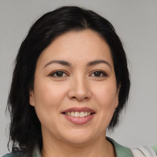 Joyful latino adult female with medium  brown hair and brown eyes
