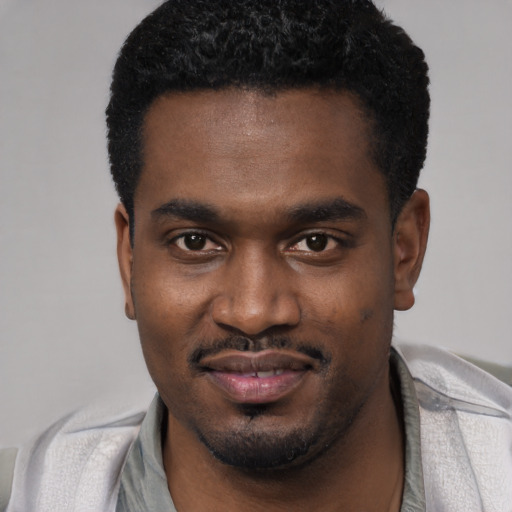Joyful black young-adult male with short  black hair and brown eyes