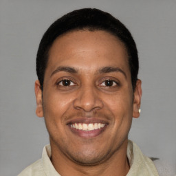 Joyful latino young-adult male with short  brown hair and brown eyes