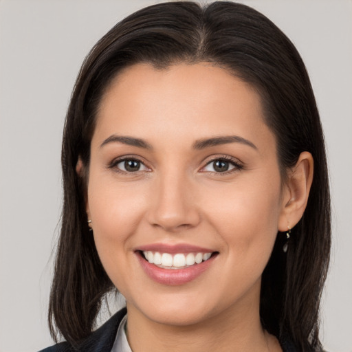 Joyful white young-adult female with long  brown hair and brown eyes