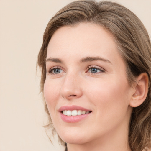 Joyful white young-adult female with medium  brown hair and blue eyes