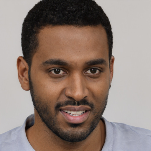 Joyful black young-adult male with short  black hair and brown eyes