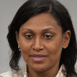 Joyful black adult female with long  brown hair and brown eyes