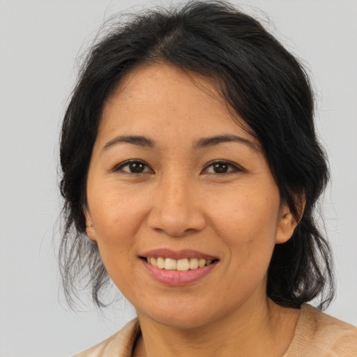 Joyful asian adult female with medium  brown hair and brown eyes