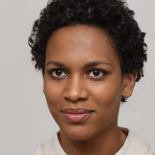 Joyful black young-adult female with short  brown hair and brown eyes