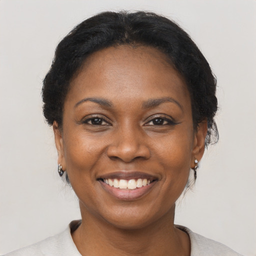 Joyful black adult female with short  black hair and brown eyes
