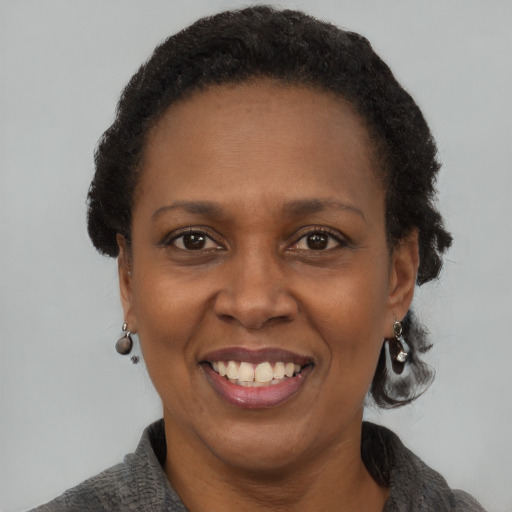 Joyful black adult female with short  brown hair and brown eyes