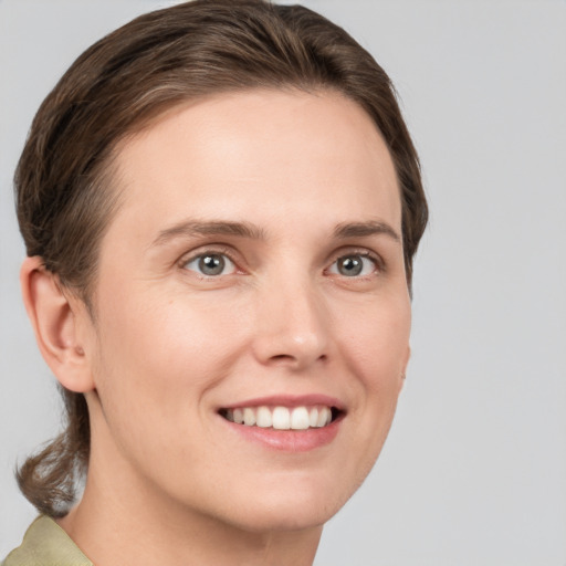 Joyful white young-adult female with medium  brown hair and grey eyes