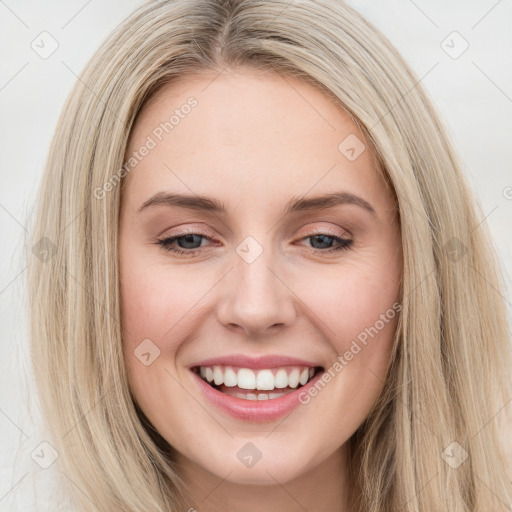 Joyful white young-adult female with long  brown hair and blue eyes