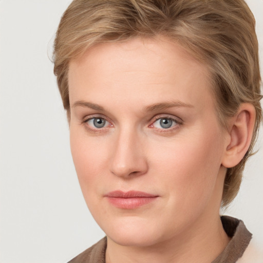 Joyful white young-adult female with medium  brown hair and blue eyes