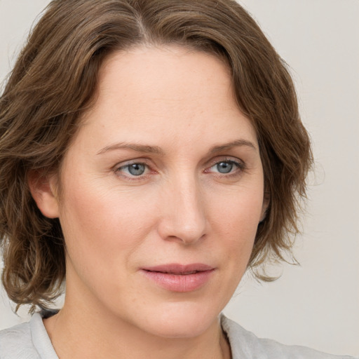 Joyful white young-adult female with medium  brown hair and blue eyes