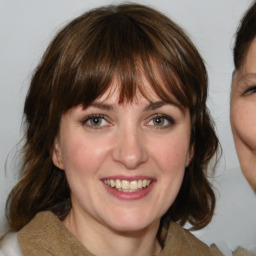 Joyful white young-adult female with medium  brown hair and blue eyes