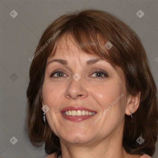 Joyful white adult female with medium  brown hair and blue eyes