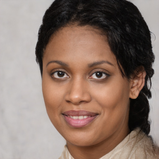 Joyful black young-adult female with long  brown hair and brown eyes