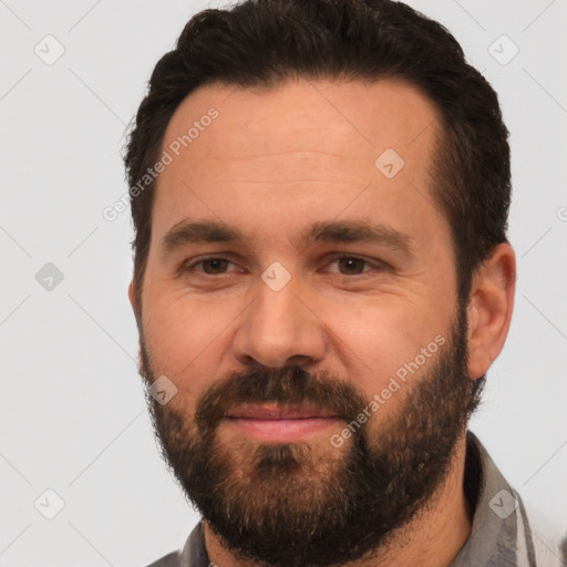 Joyful white adult male with short  black hair and brown eyes