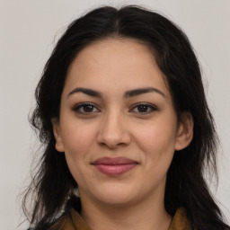 Joyful latino young-adult female with long  brown hair and brown eyes