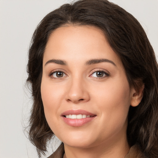 Joyful white young-adult female with long  brown hair and brown eyes