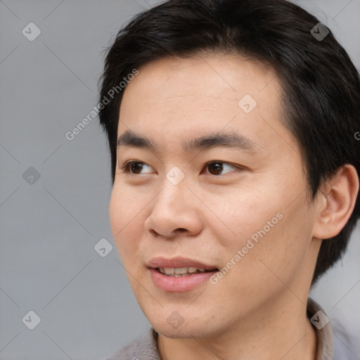 Joyful asian young-adult male with short  brown hair and brown eyes