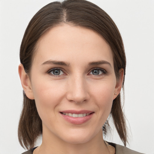 Joyful white young-adult female with medium  brown hair and grey eyes