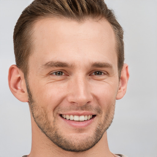 Joyful white young-adult male with short  brown hair and grey eyes