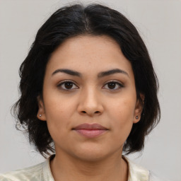 Joyful latino young-adult female with medium  brown hair and brown eyes