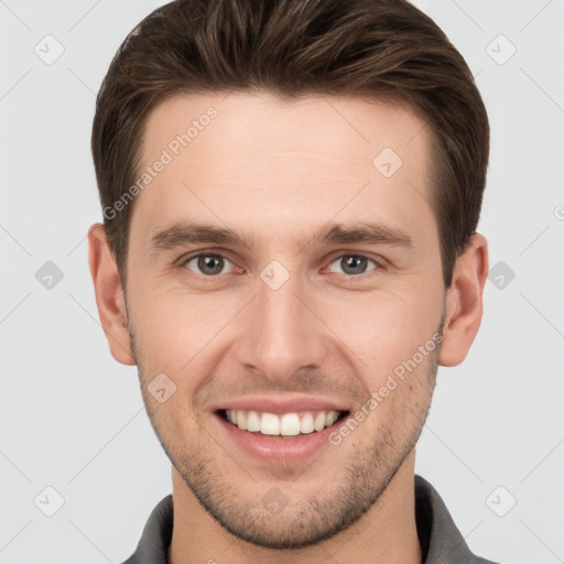 Joyful white young-adult male with short  brown hair and grey eyes