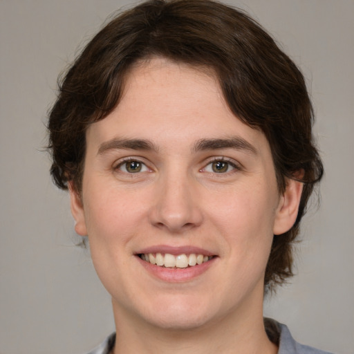 Joyful white young-adult male with medium  brown hair and grey eyes