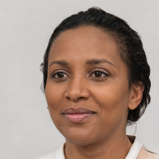 Joyful black adult female with short  black hair and brown eyes