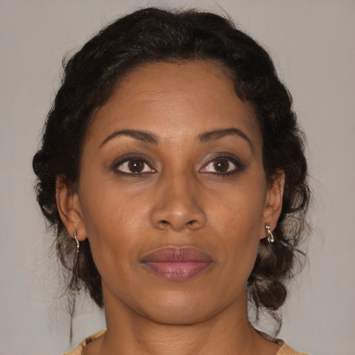Joyful black adult female with medium  brown hair and brown eyes