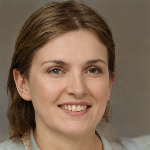 Joyful white young-adult female with medium  brown hair and grey eyes