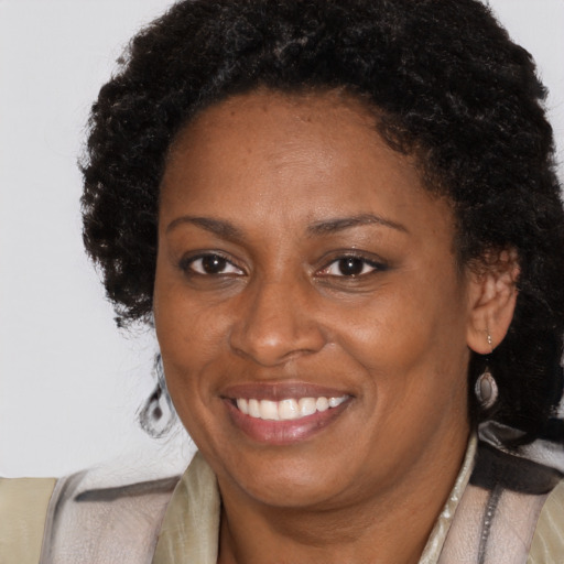 Joyful black adult female with long  brown hair and brown eyes