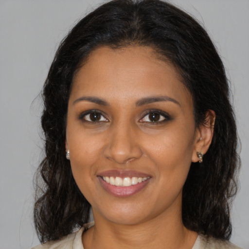 Joyful black young-adult female with long  brown hair and brown eyes