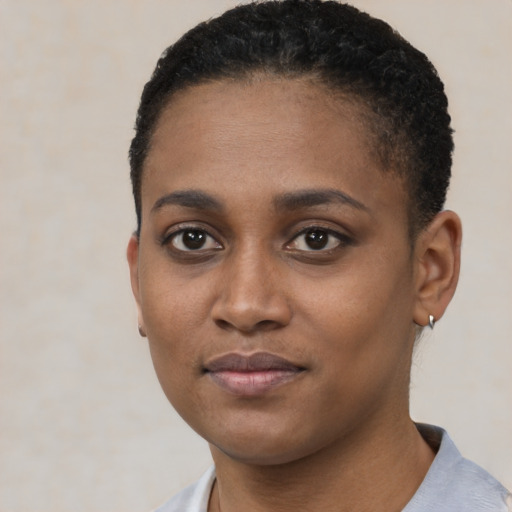 Joyful black young-adult female with short  black hair and brown eyes