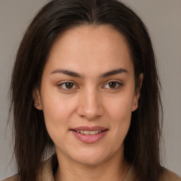 Joyful latino young-adult female with long  brown hair and brown eyes