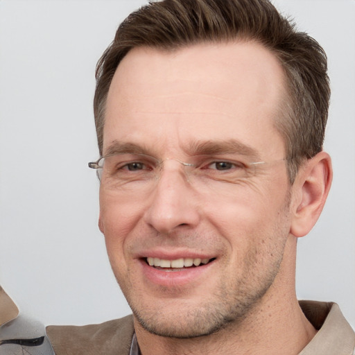 Joyful white adult male with short  brown hair and grey eyes