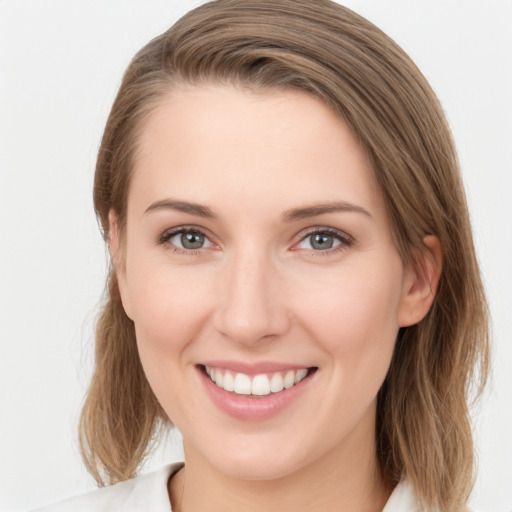 Joyful white young-adult female with medium  brown hair and grey eyes